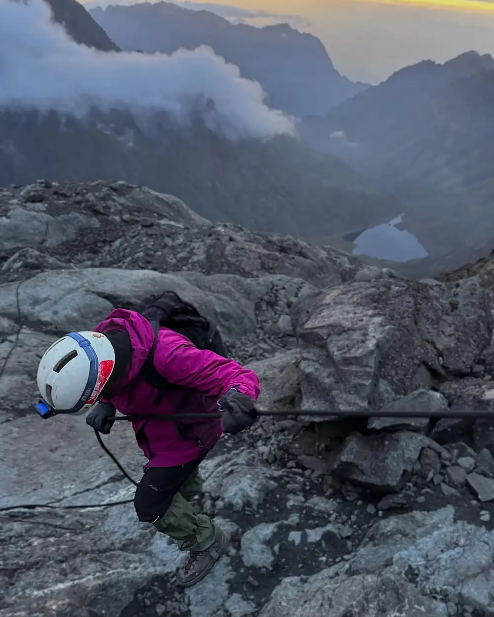Climber moving across rock terrain in the Rwenzori Mountains