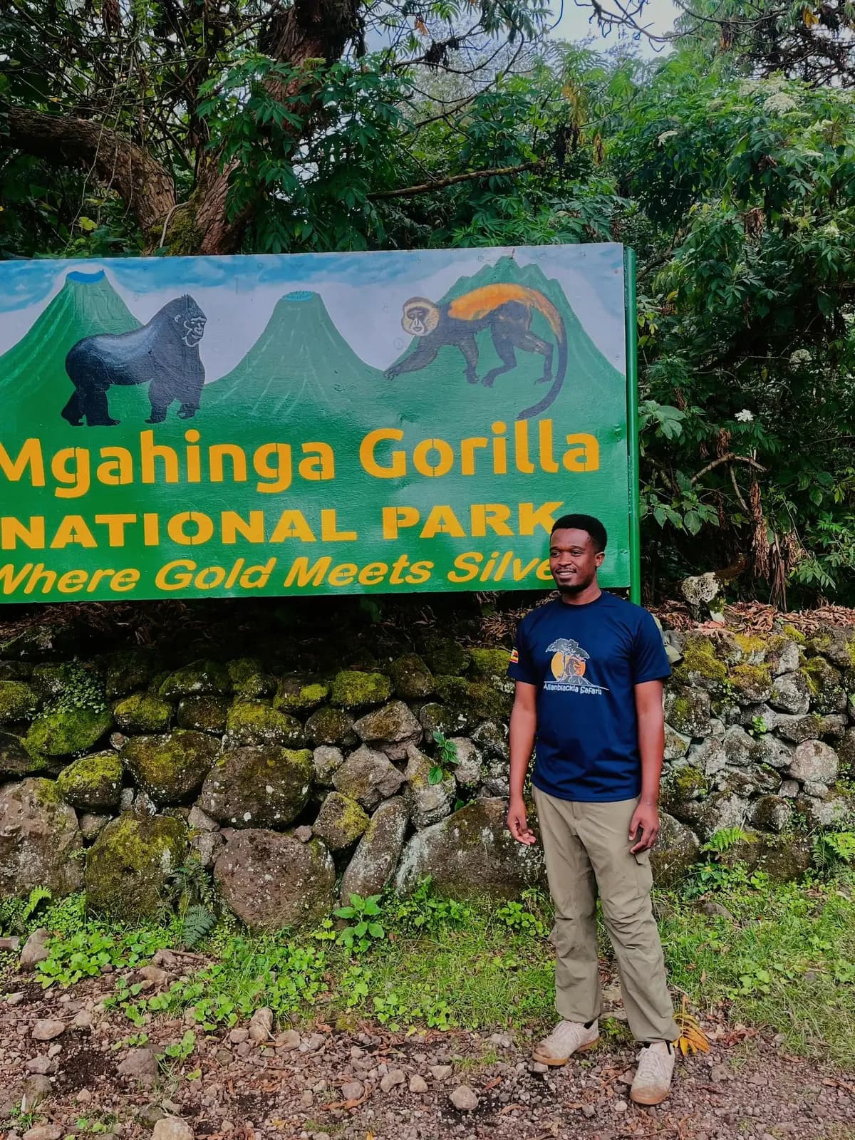 Guide standing beside the Mgahinga Gorilla National Park sign