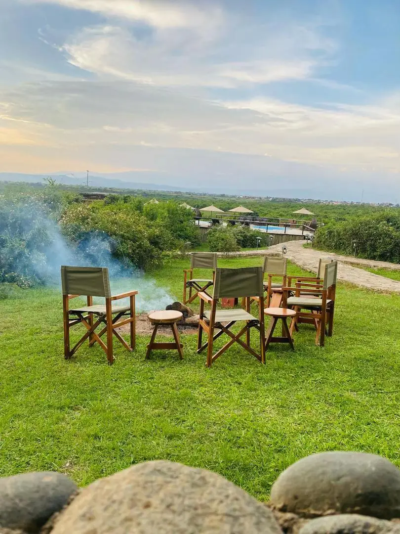 Outdoor safari dining chairs and table looking across a Uganda landscape